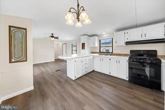 a kitchen with stainless steel appliances granite countertop a stove cabinets and wooden floor