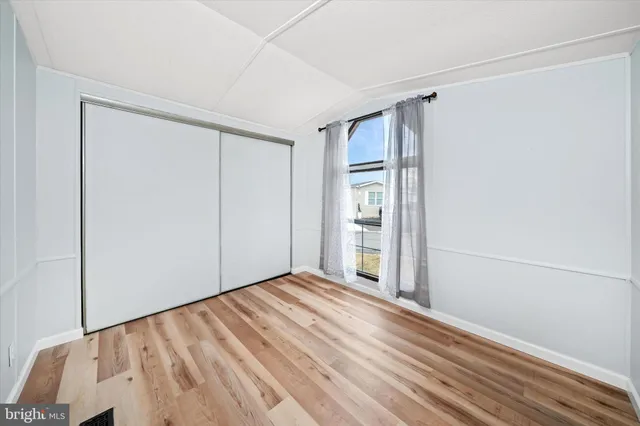 a view of empty room with wooden floor