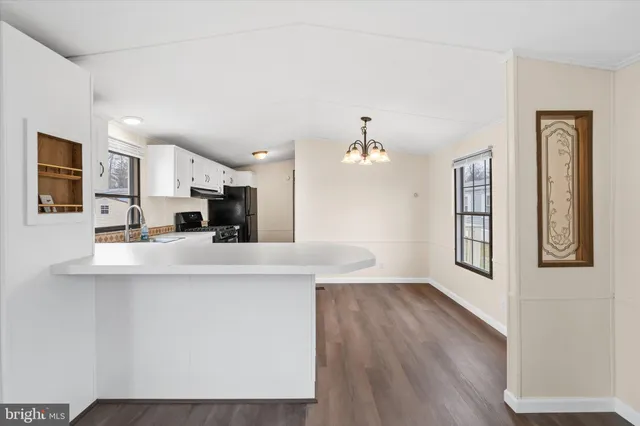 a view of a kitchen with stainless steel appliances granite countertop a sink and a refrigerator