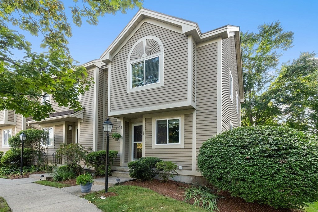 a view of house with a yard and potted plants