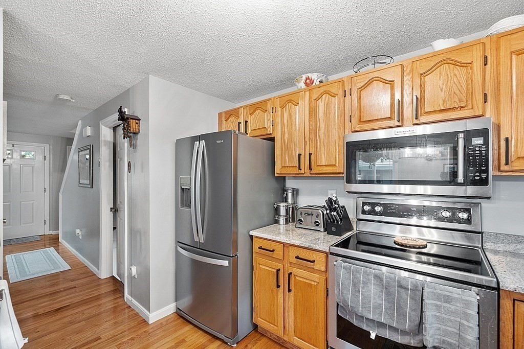 55 Littleton Road, Unit 2F Ayer, MA 01432 - Photo 11 of 29 a kitchen with stainless steel appliances granite countertop a refrigerator and a stove top oven