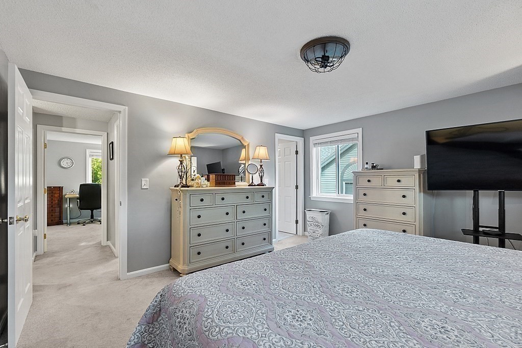 55 Littleton Road, Unit 2F Ayer, MA 01432 - Photo 15 of 29 a bedroom with a bed and a flat screen tv