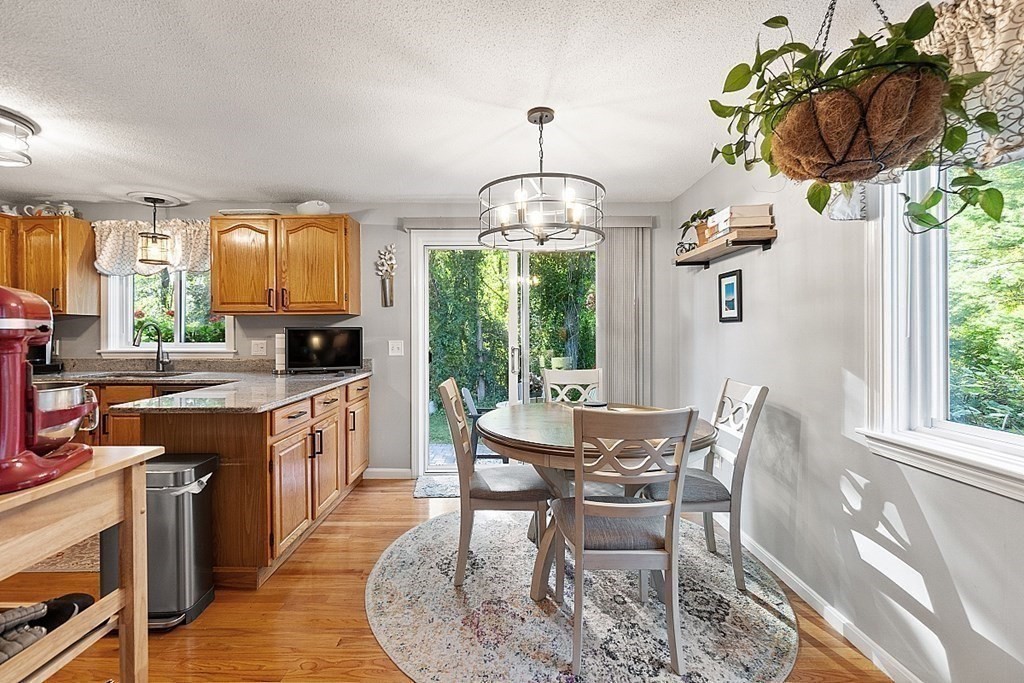 55 Littleton Road, Unit 2F Ayer, MA 01432 - Photo 6 of 29 a dining room with furniture a chandelier and wooden floor