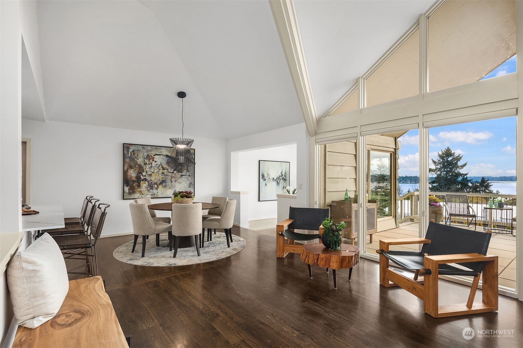 8457 Midland Road Medina, WA 98039 - Photo 10 of 40 a dining room with wooden floor a chandelier a glass table and chairs
