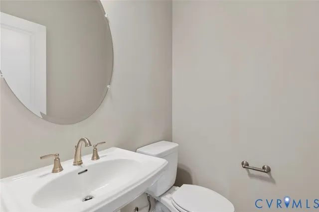 a bathroom with a toilet a sink and mirror