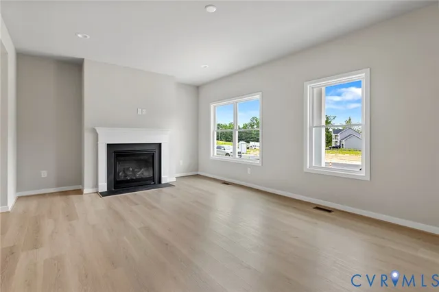 an empty room with windows and fireplace