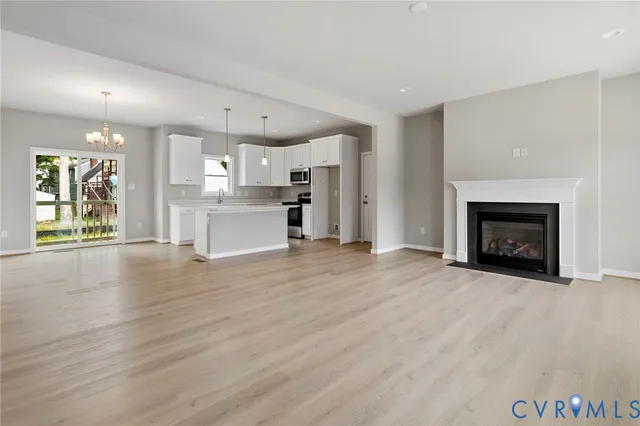 a view of a kitchen and an empty room with a fireplace