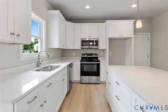 a kitchen with granite countertop a sink stove and refrigerator