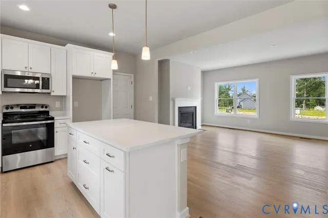 a kitchen with stainless steel appliances kitchen island granite countertop a stove a sink and a refrigerator