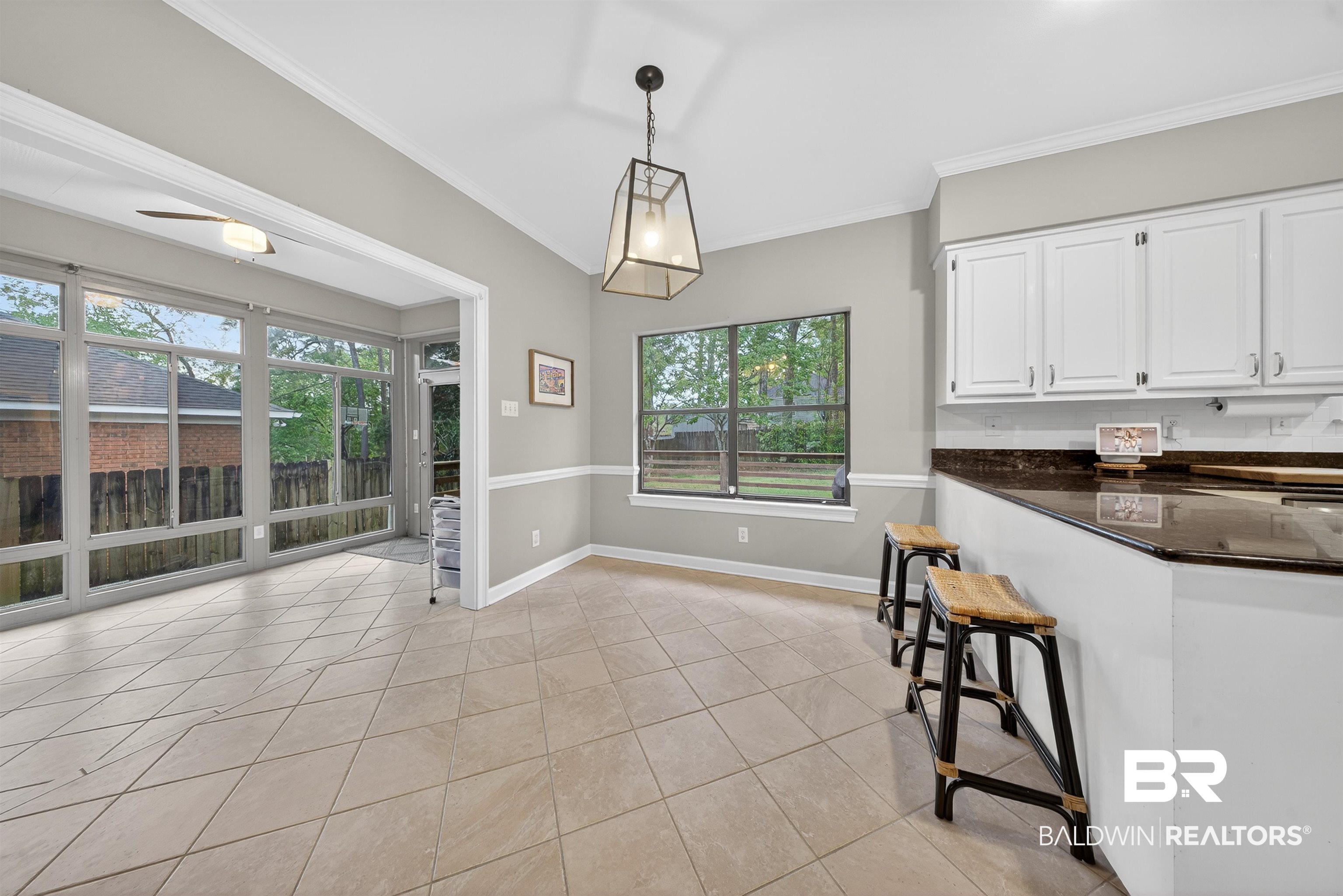 1250 Savannah Drive Mobile, AL 36609 - Photo 12 of 35 Kitchen featuring dark stone countertops, hanging light fixtures, ornamental molding, white cabinets, and light tile patterned flooring