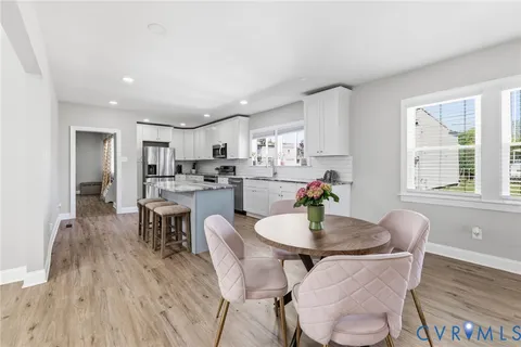 a kitchen with a dining table chairs and refrigerator