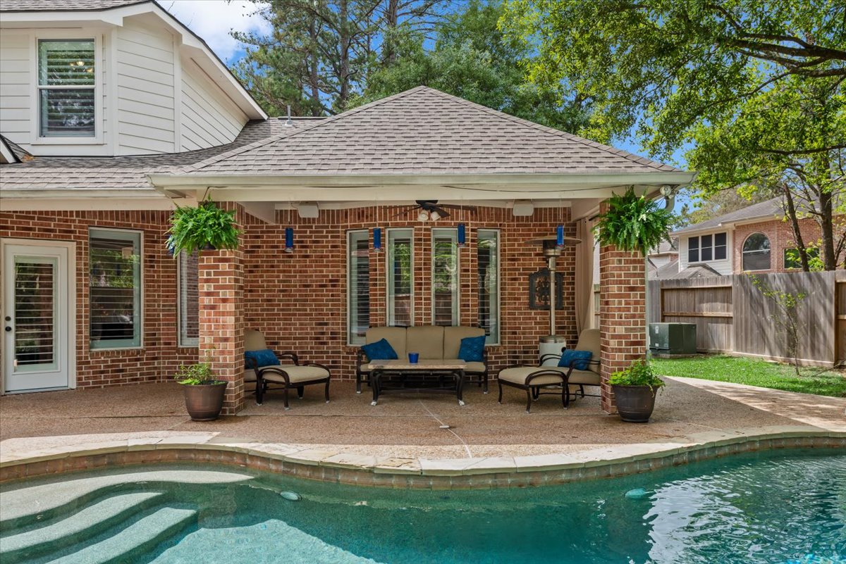 15519 Stallion Point Circle Cypress, TX 77429 - Photo 33 of 37 The property features an inviting outdoor living area with a covered patio, brick columns, and a view of the pool