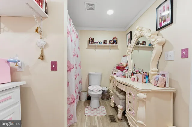 a bathroom with a sink vanity mirror and toilet