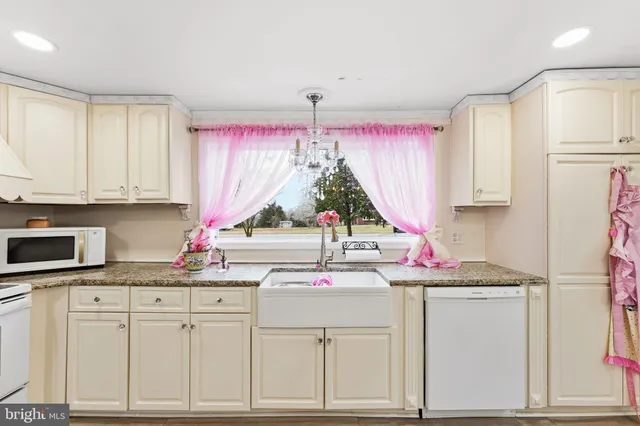 a kitchen with white cabinets and sink