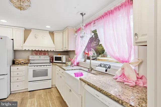 a kitchen with white cabinets and white appliances