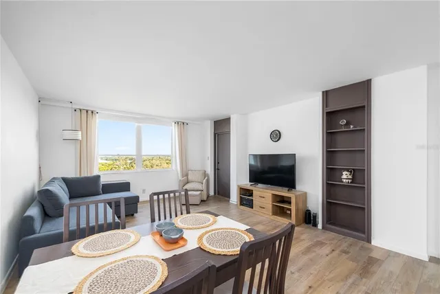 a dining room with furniture a window and a flat screen tv