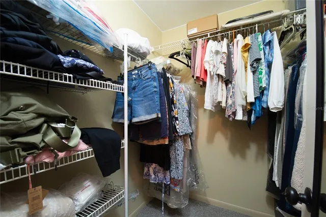 a view of walk in closet with clothes and shoes
