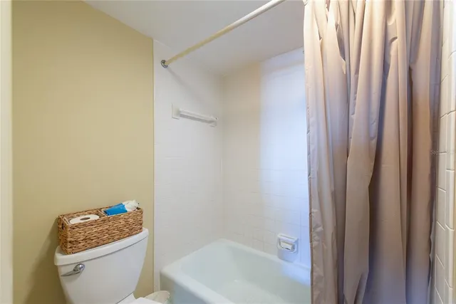 a white toilet sitting next to a bath tub