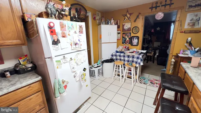 a room with lots of white furniture and refrigerator