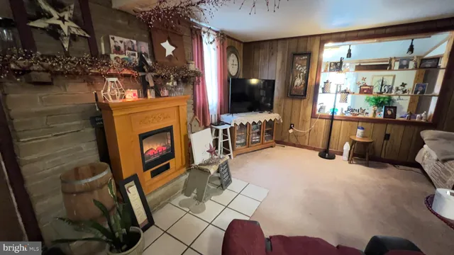 a living room with furniture a fireplace and a floor to ceiling window