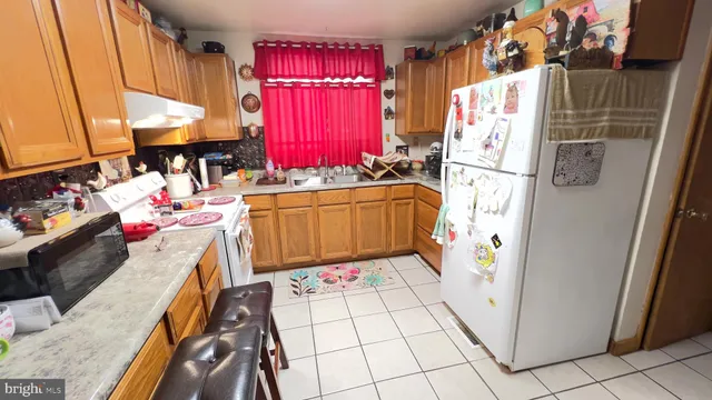 a kitchen with red cabinets a stove and a refrigerator
