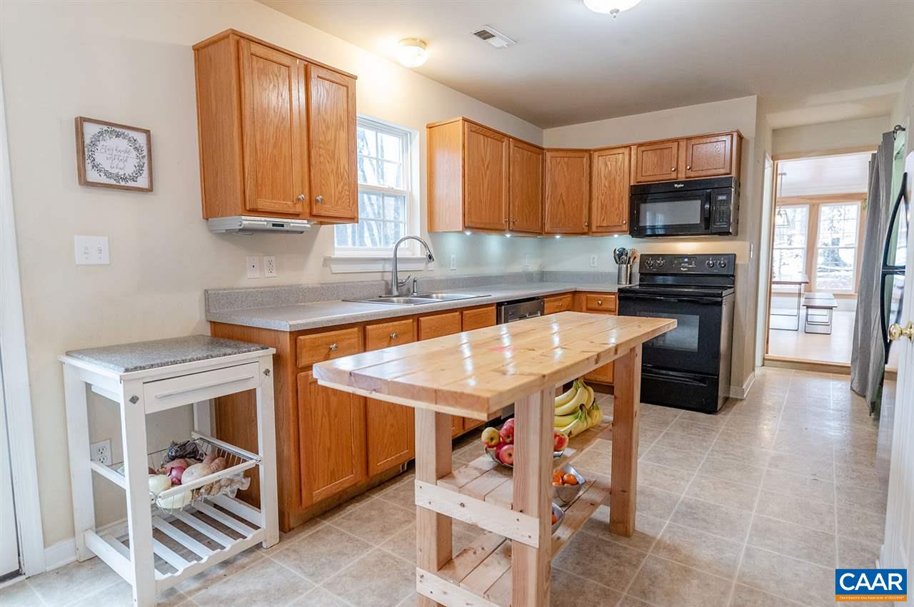 3683 Irish Road Esmont, VA 22937 - Photo 12 of 42 a kitchen with stainless steel appliances granite countertop a stove top oven a sink and a microwave