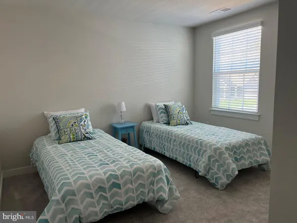 a bedroom with two beds and a window
