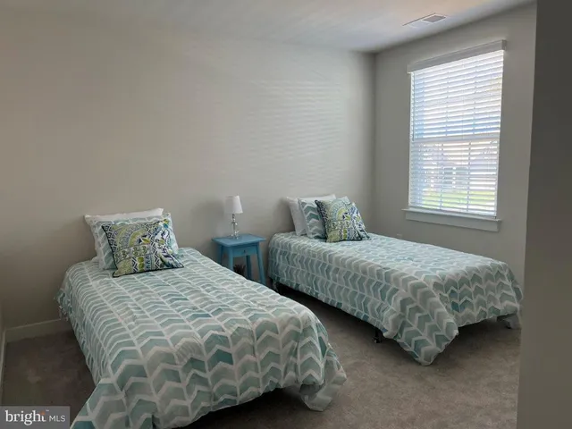 a bedroom with two beds and a window