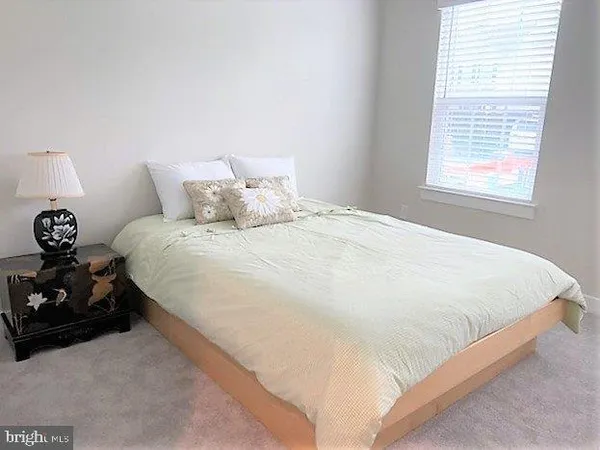 a large bed sitting in a bedroom next to a window