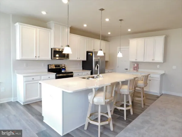 a kitchen with appliances a sink and cabinets
