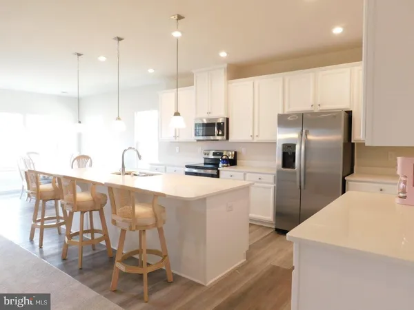 a kitchen with kitchen island a counter top space appliances and cabinets