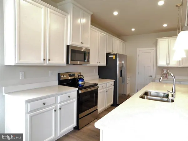 a kitchen with kitchen island granite countertop a sink stainless steel appliances and cabinets