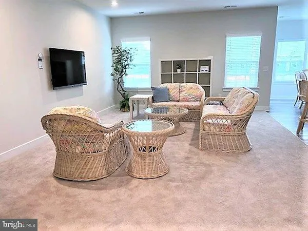a living room with furniture a flat screen tv and large window