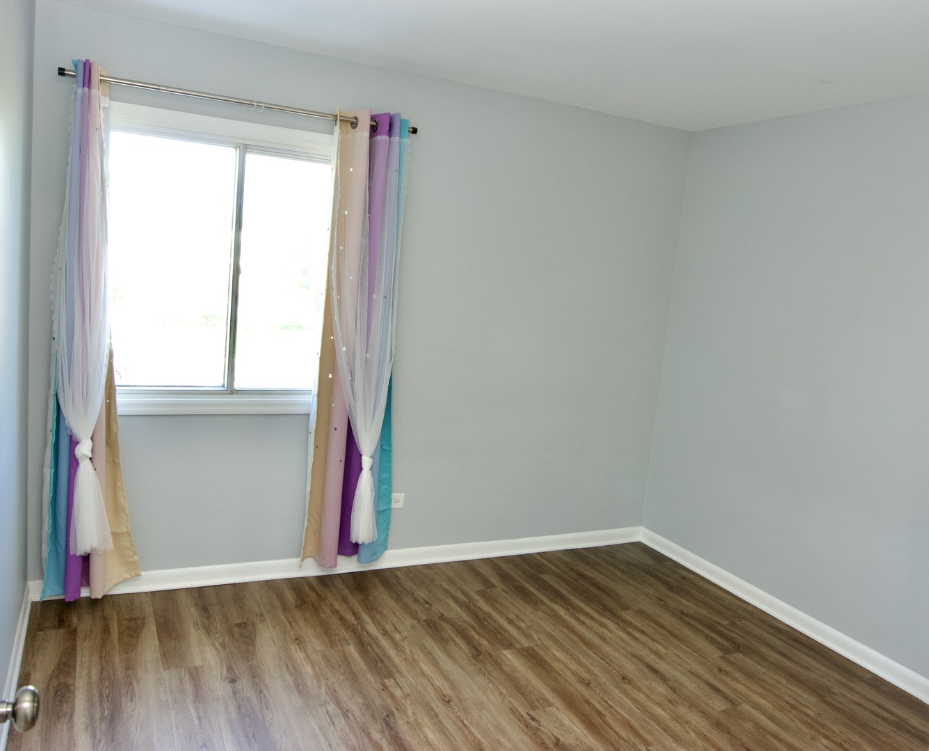 10347 Dearlove Road, Unit 301 Glenview, IL 60025 - Photo 10 of 13 a view of an empty room with wooden floor and a window