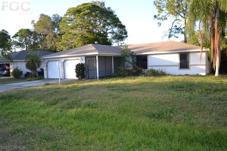 9185 Pomelo Road East Fort Myers, FL 33967 - Photo 13 of 13 a front view of a house with a garden and trees