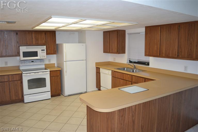9185 Pomelo Road East Fort Myers, FL 33967 - Photo 2 of 13 a kitchen with a sink appliances and cabinets