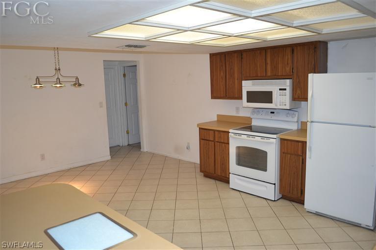 9185 Pomelo Road East Fort Myers, FL 33967 - Photo 3 of 13 a kitchen with a stove a washer and dryer