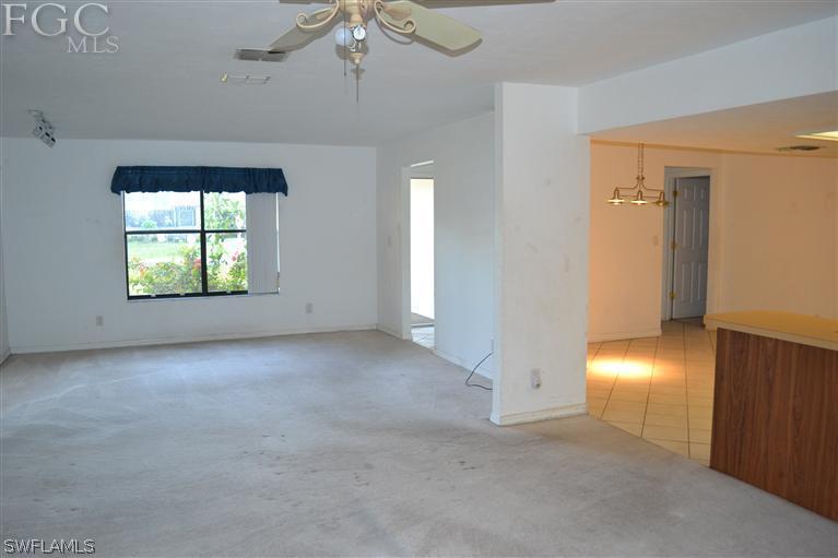 9185 Pomelo Road East Fort Myers, FL 33967 - Photo 5 of 13 an empty room with chandelier fan and windows