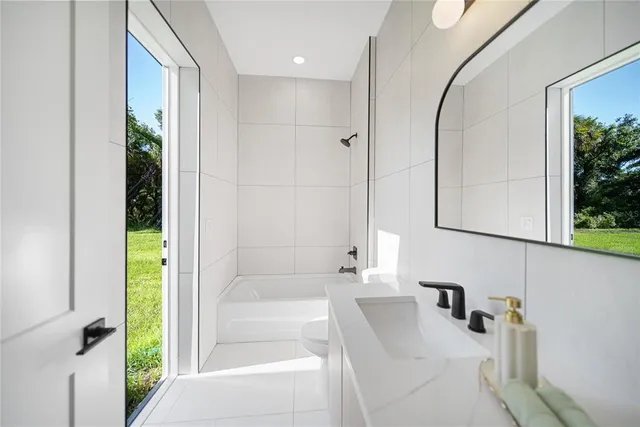 a bathroom with a double vanity sink a mirror and a bathtub