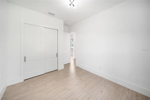 a large white kitchen with wooden floors and a fireplace
