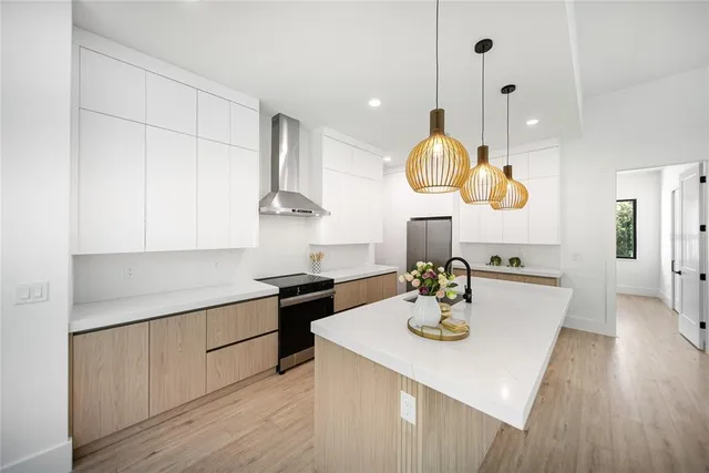 an aerial view of residential houses with outdoor space and trees