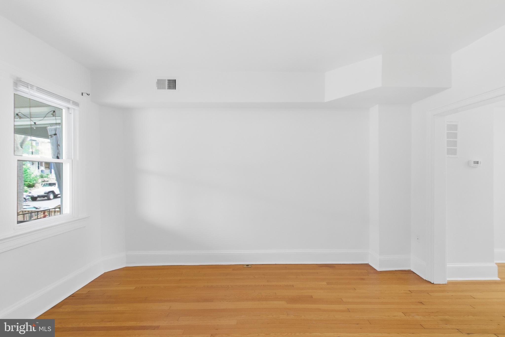 440 Delafield Place Northwest Washington, DC 20011 - Photo 7 of 33 a view of an empty room with wooden floor and a window