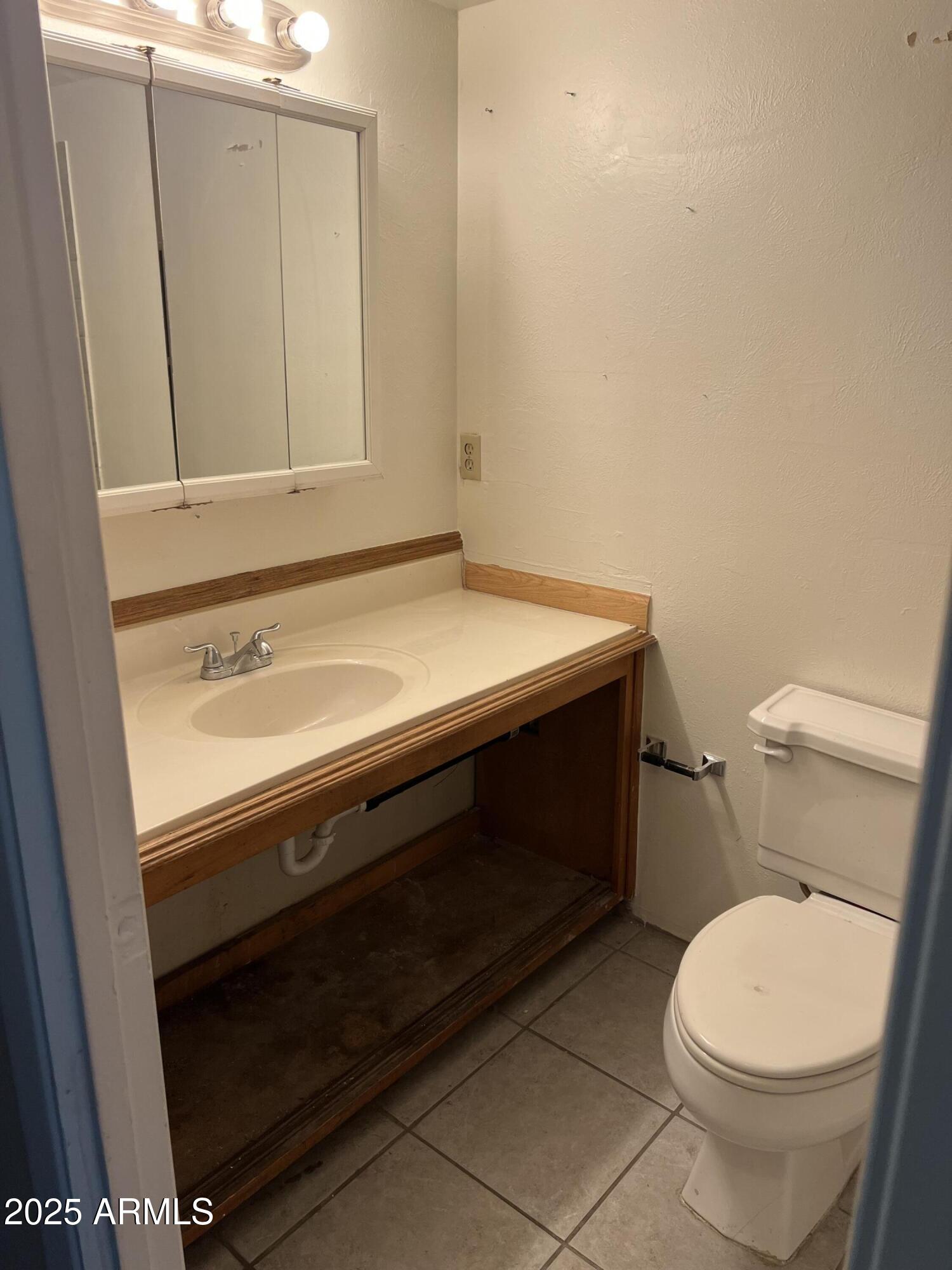 2530 West Berridge Lane, Unit E102 Phoenix, AZ 85017 - Photo 14 of 15 a bathroom with a sink a toilet and vanity