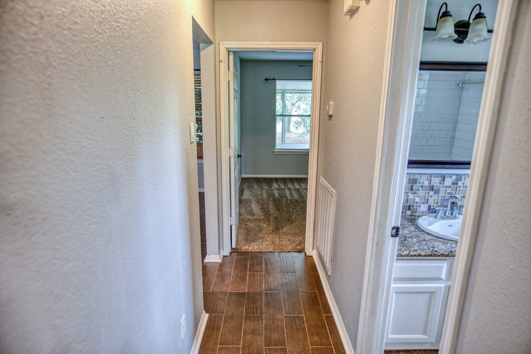 308 County Road 893B Angleton, TX 77515 - Photo 25 of 41 a view of a hallway with wooden floor and a bathroom