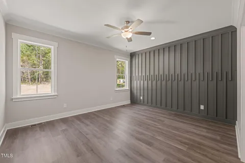 a view of an empty room with a window and wooden floor