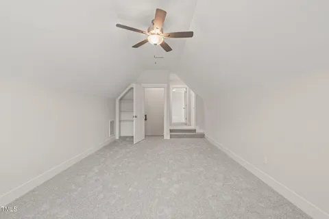 an empty room with a ceiling fan and a window