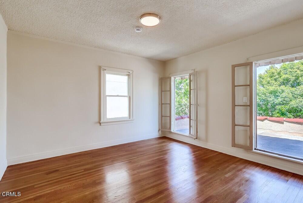 833-835 North Ridgewood Place Los Angeles, CA 90038 - Photo 15 of 28 a view of an empty room with wooden floor and a window