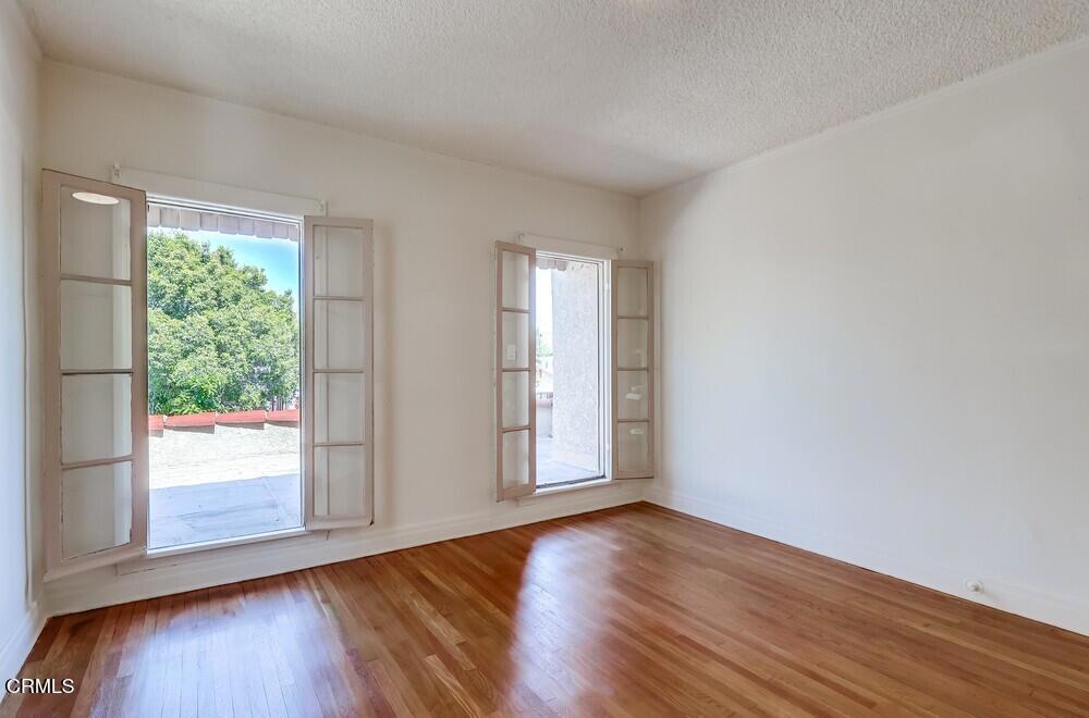 833-835 North Ridgewood Place Los Angeles, CA 90038 - Photo 16 of 28 an empty room with wooden floor and windows