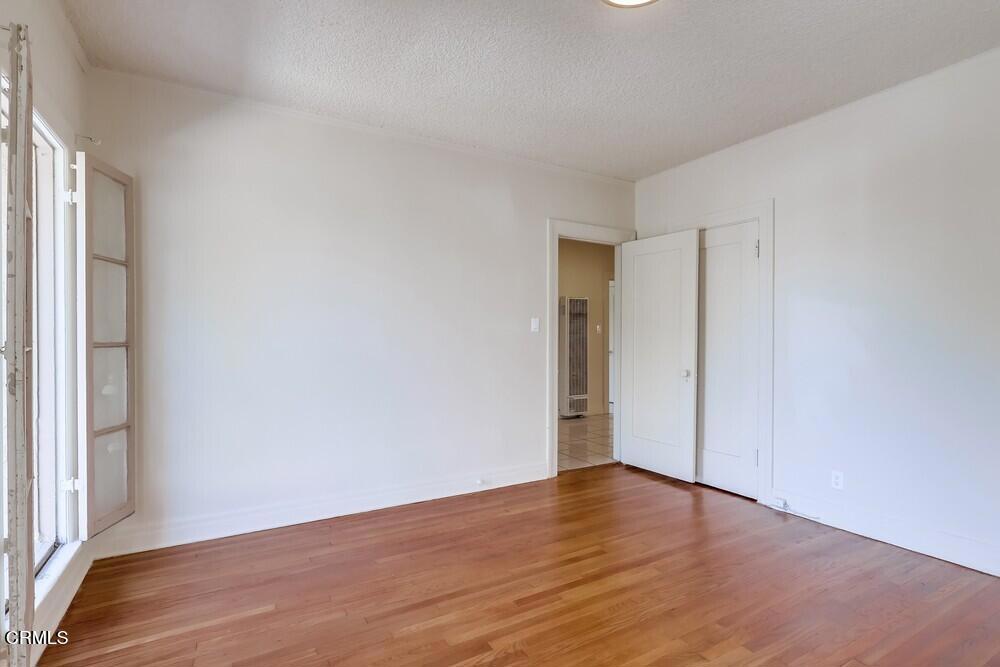 833-835 North Ridgewood Place Los Angeles, CA 90038 - Photo 17 of 28 a view of an empty room with wooden floor and a window