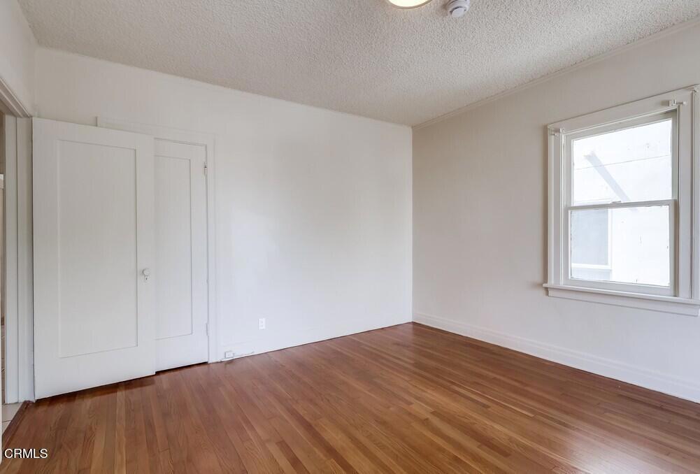 833-835 North Ridgewood Place Los Angeles, CA 90038 - Photo 18 of 28 a view of empty room with wooden floor and fan